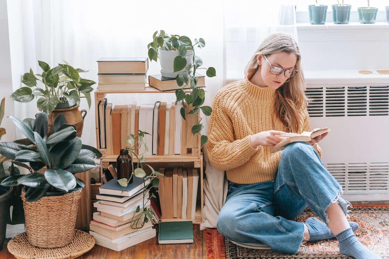 woman sitting near the bookshelf