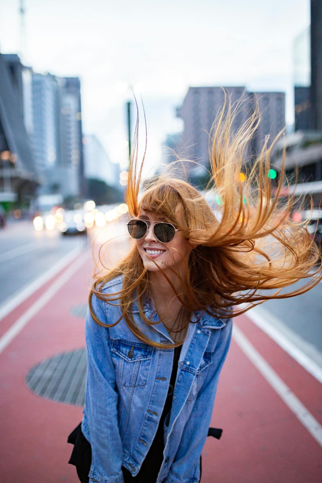 Woman enjoying the wind blowing her hair which represents the romanticizing of her life