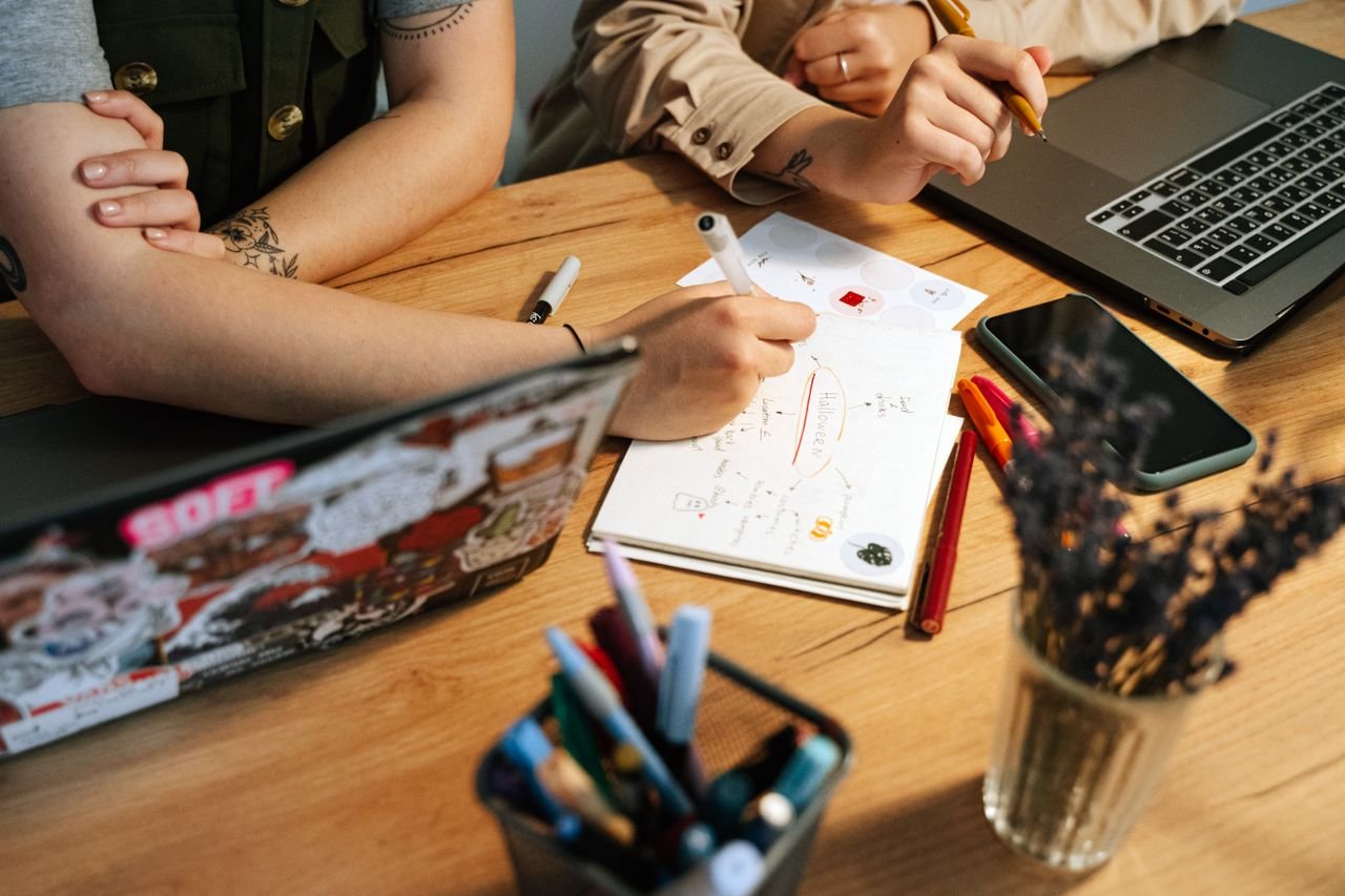 people working with a closed phone on the table