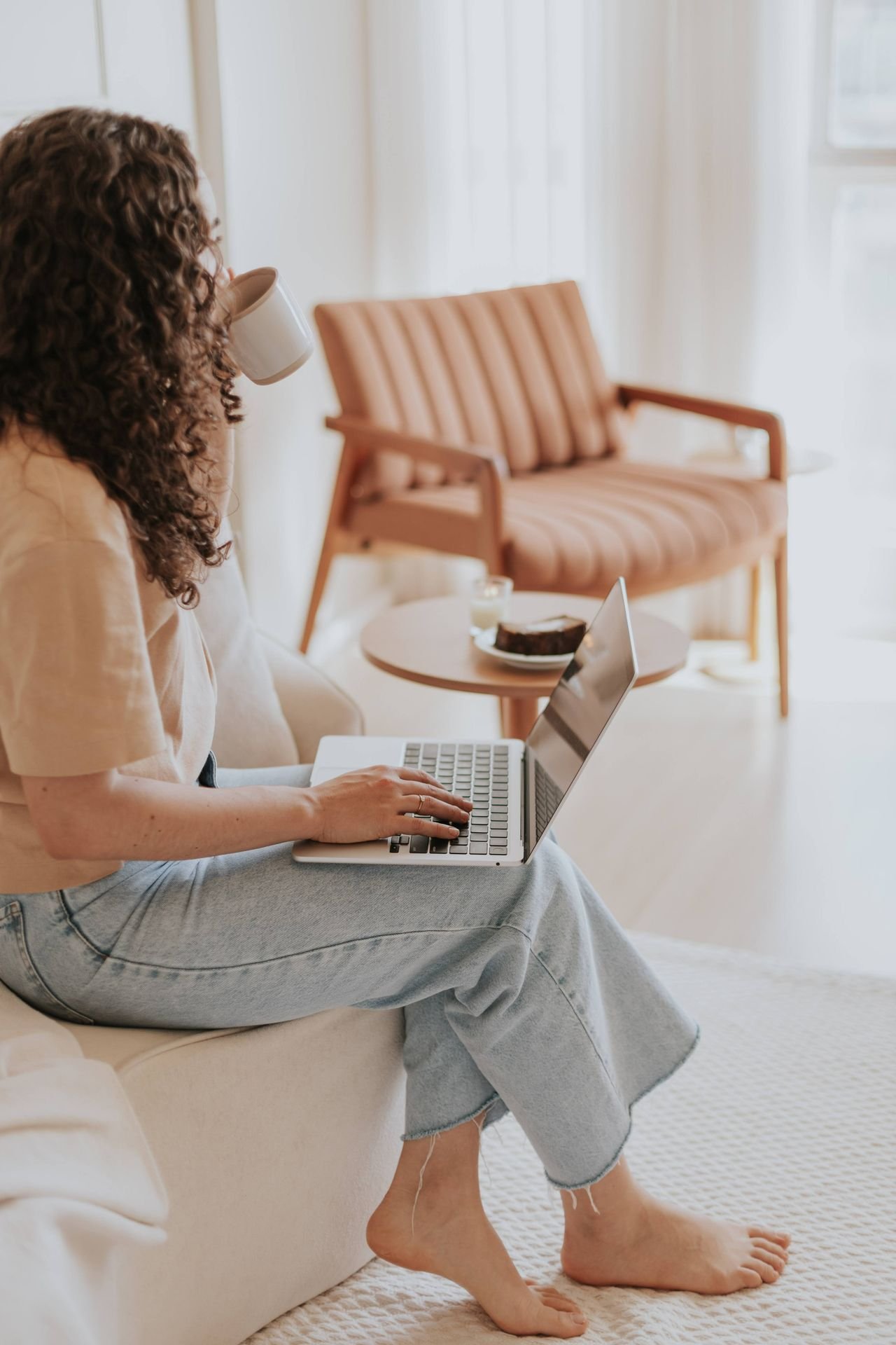 barefoot woman with laptop working from home