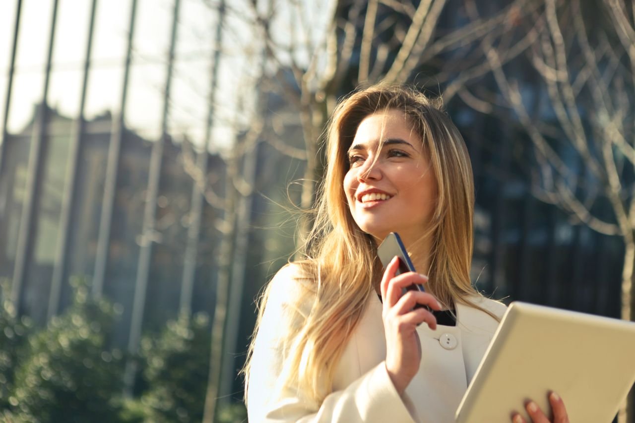 woman looking away from phone smiling