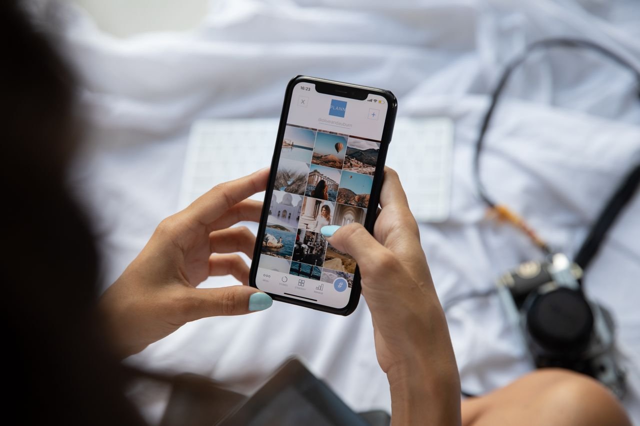 person holding phone scrolling on social media
