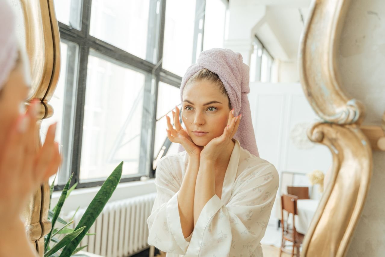 woman in front of mirror doing skin care