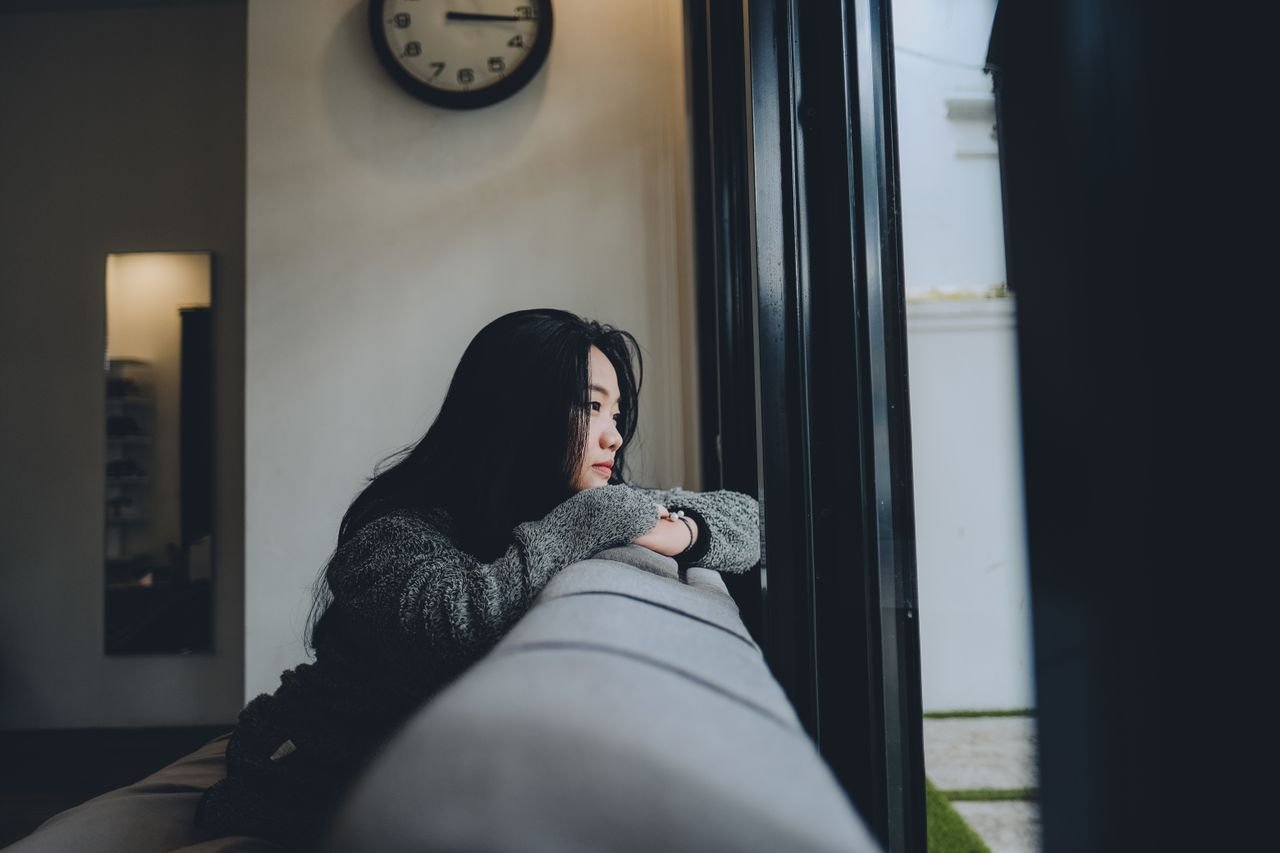 A contemplative woman looking outside the window