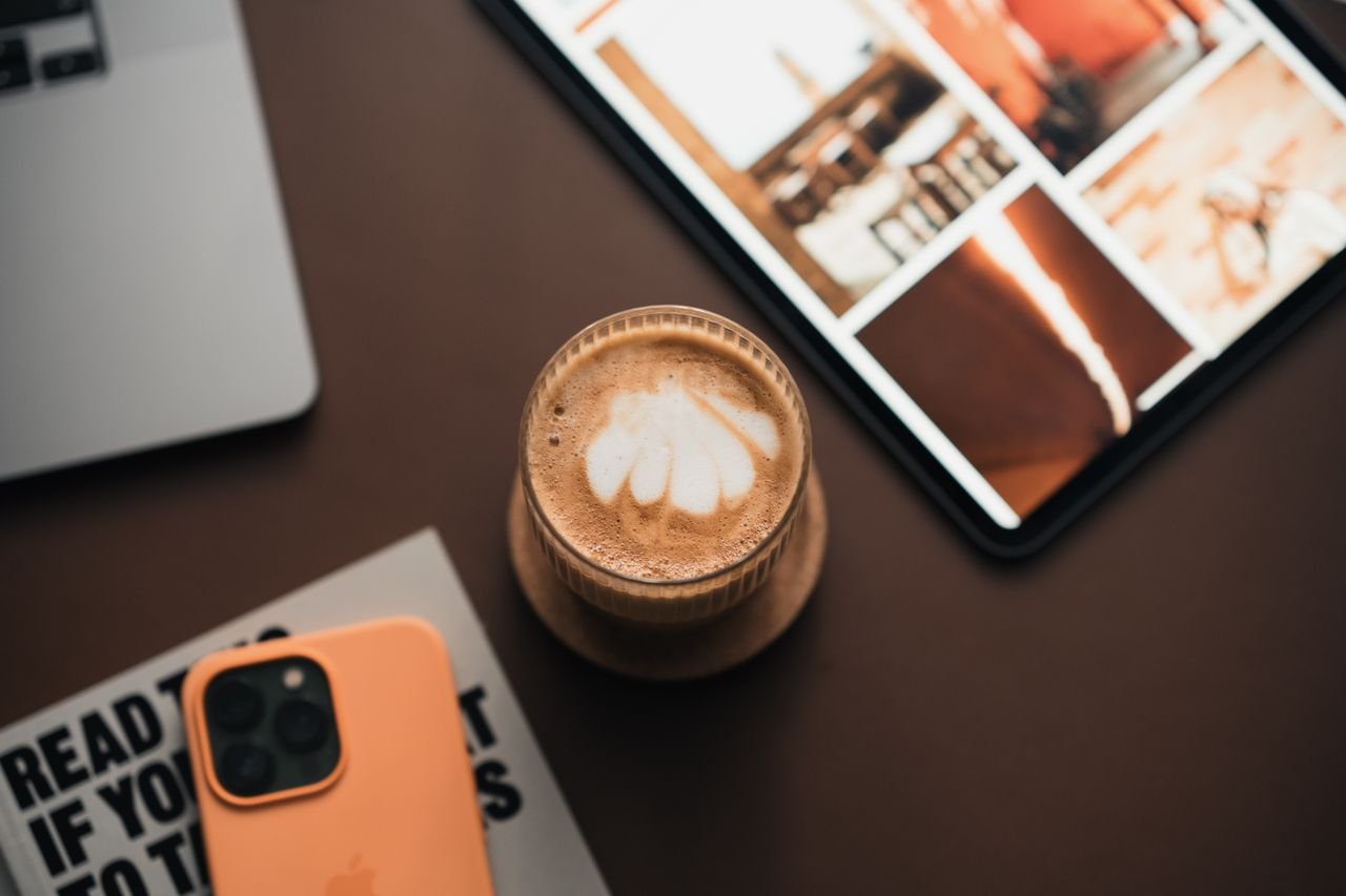 coffee on desk with phone facing down