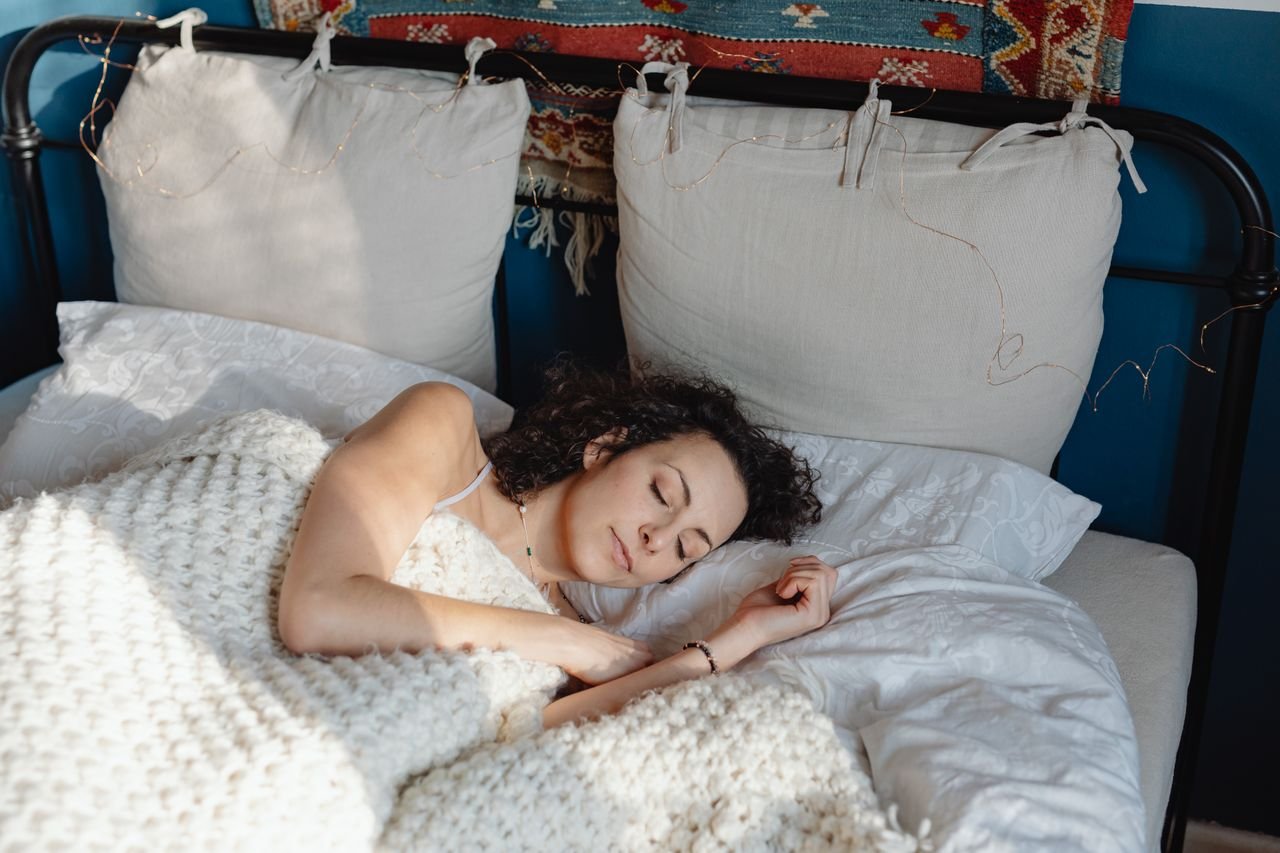 woman sleeping under a wool blanket