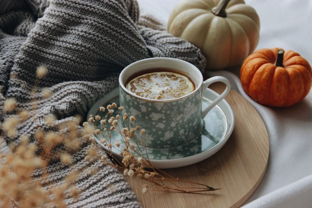 cozy cup of tea next to pumpkins