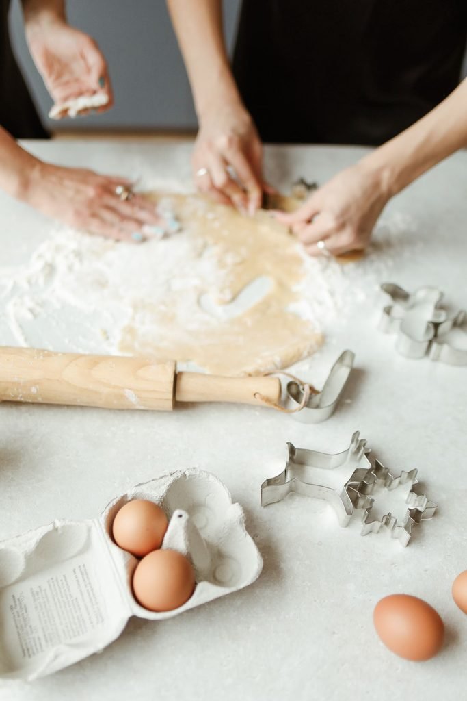 Self-care on a budget: woman cutting cookie dough with a cookie cutter